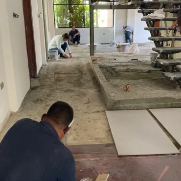 Personal de la constructora realizando medición para colocación de pisos en interiores