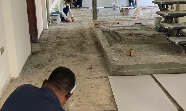 Trabajos de acabados interiores en ejecución de obra Personal de la constructora realizando medición para colocación de pisos en interiores