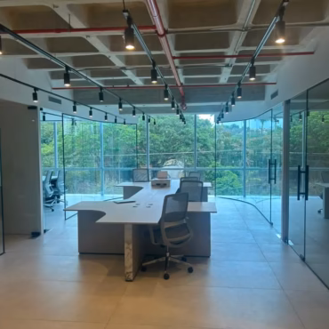 Remodelación y acabados en espacio de oficinas corporativas con estilo industrial y mamparas de vidrio